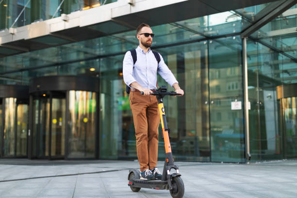istock Young adult man using electro scooter at the city 1421373685