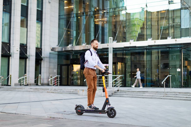 istock Young adult man using electro scooter at the city 1421373714