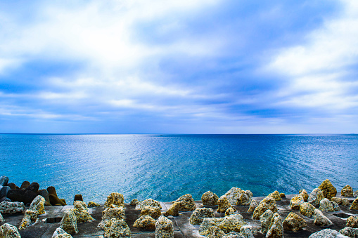 blue sea and sky with clouds over it