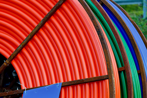 Close-up view of multi-colored utility cables rolled up ready to be placed underground.