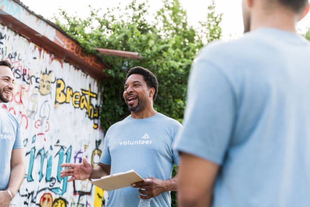 istock Adult volunteer manager talks to the group 1421375948