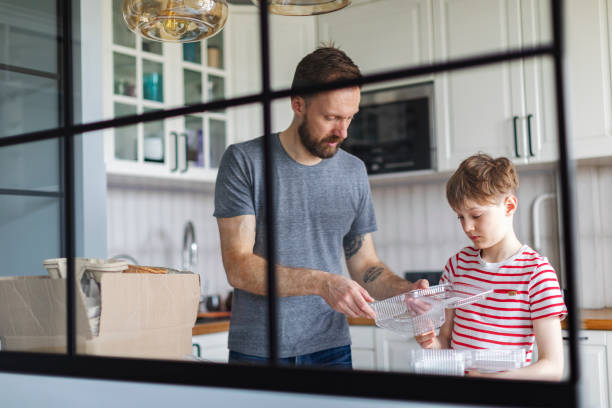 istock Father and son sorting waste at home for recycling 1421376208