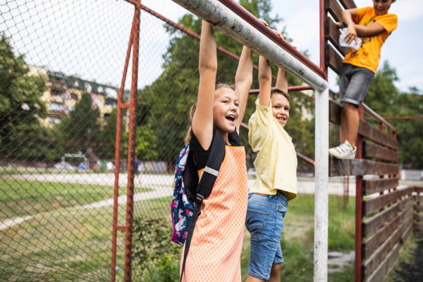 istock School kids hanging from a goal post at recess 1421378326