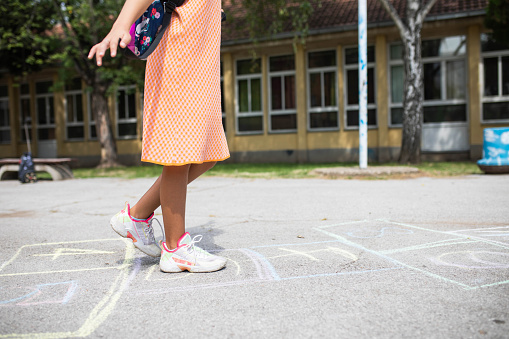 A cropped shot of a tweenaged girl playing hopscotch