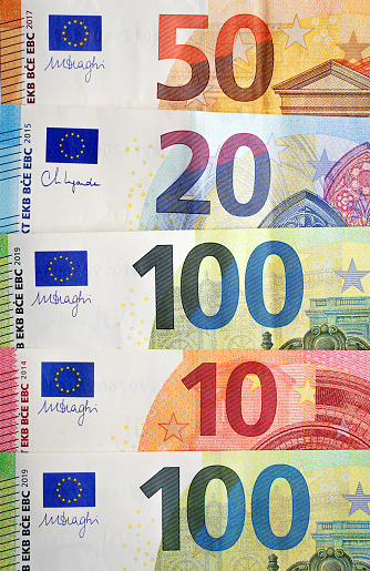 Top view of mixed euro currency banknotes in a row with focus on the numbers
