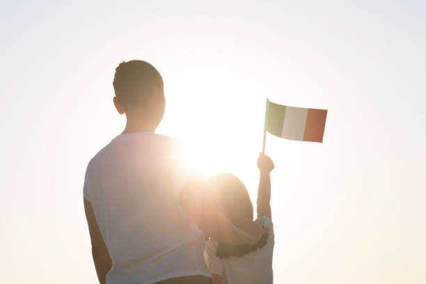 Little Girl and Mother with Flag Back view of little girl and mother holding Italian flag in hand. italian ethnicity stock pictures, royalty-free photos & images