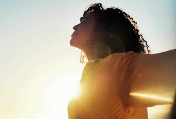 liberté, éclat et ciel avec une femme en plein air au coucher du soleil pendant l’été pour se détendre avec l’air frais et le soleil. heureux, insouciant et maquette avec une jeune femme se sentant détendue dehors le matin - clear sky flash photos et images de collection