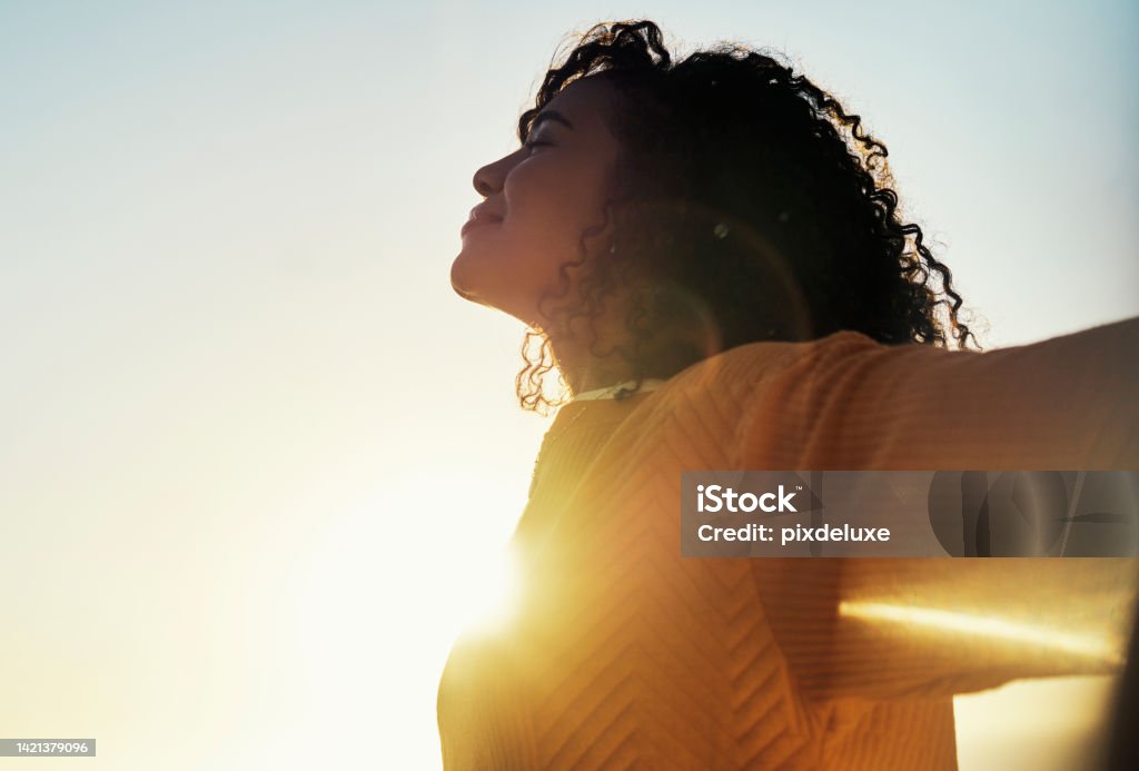 Freedom, flare and sky with a woman outdoor at sunset during summer to relax with fresh air and sunshine. Happy, carefree and mockup with a young female feeling relaxed outside in the morning Happiness Stock Photo