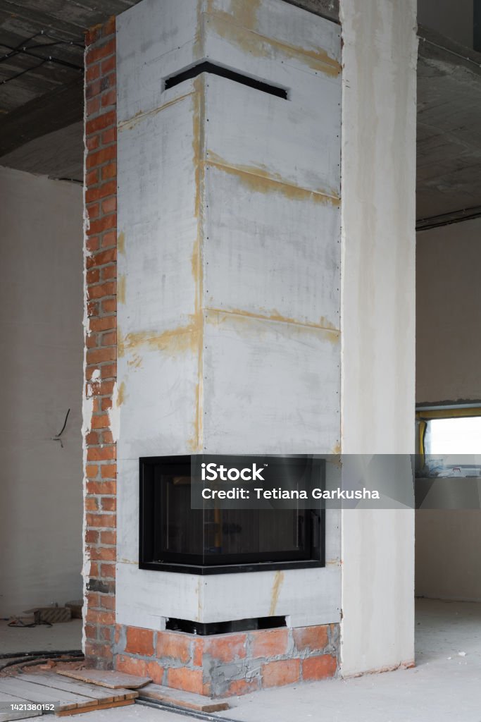 Fireplace installation Installing of manufactured enclosed corner fireplace with calcium silicate insulation slabs. House construction and renovation Chimney Stock Photo
