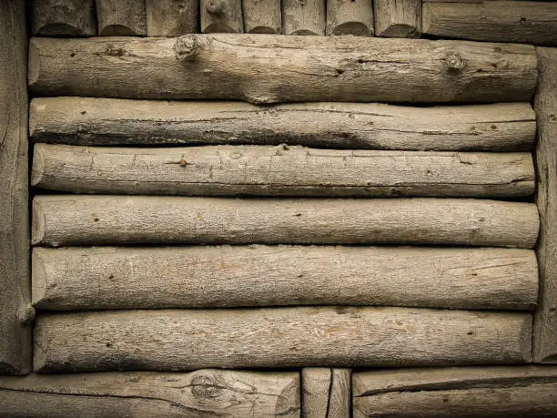 Logs horizontal and vertical in log-cabin wall pattern closeup.