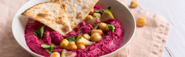 istock Close-up of Beetroot hummus on white table 1421380478