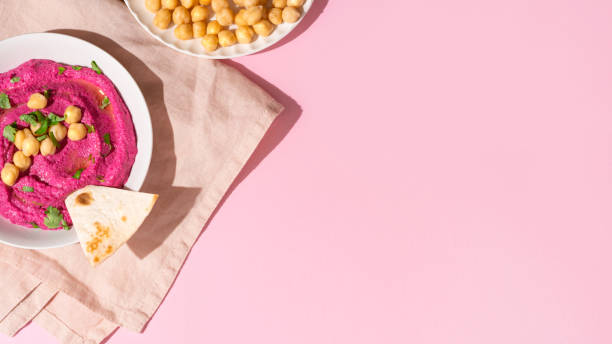istock Beetroot hummus on pink background, top view and copy space 1421382078