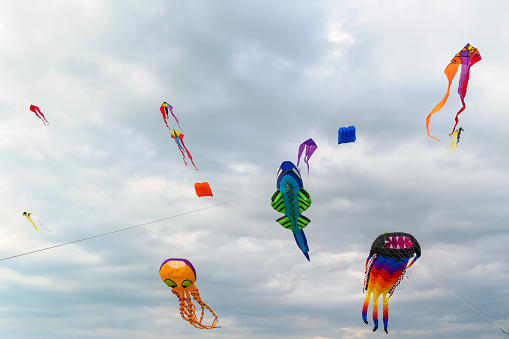 A lot of colorful kites on the background of a cloudy sky with clouds