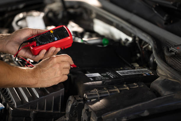 istock Mechanic doing car inspection, he is testing car battery with tester. Check battery voltage with electric multimeter. Man using multimeter to measure the voltage of the batteries 1421386987