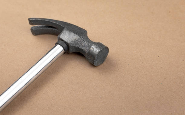 istock Iron hammer isolated on a table with a textured brown paper background 1421387763