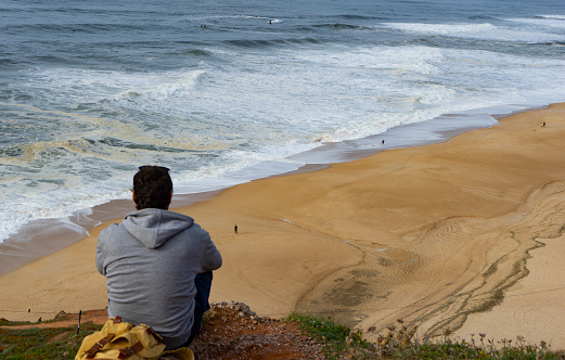 Panoramic view of a man meditating on a cliff