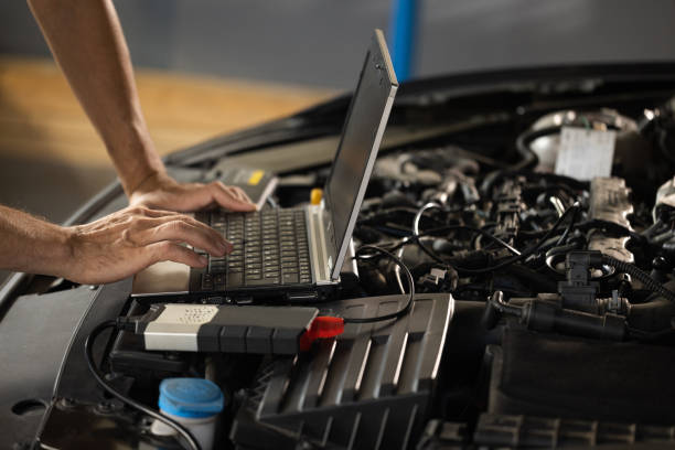 istock Auto mechanic uses laptop while conducting diagnostics test. Modern car service. Computer diagnostics of the car. European car mechanic holds a digital device 1421389231
