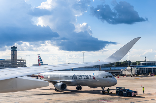 Charlotte NC, USA - Aug 8th, 2022  Ground personnel are guiding an airplane of American Airlines to its position at Charlotte Douglas International Airport, NC, USA