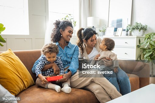 istock Female gay couple with kids at home 1421391455