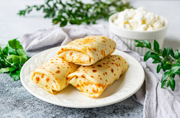 Pancakes stuffed with cottage cheese and herbs on a white plate