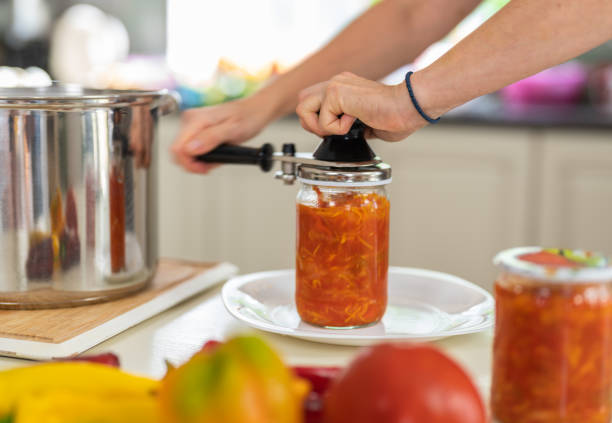 conservação caseira de legumes. uma mulher de perto preserva uma salada de legumes em um pote de vidro - jar canning food preserves - fotografias e filmes do acervo