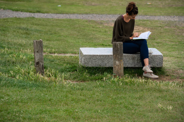 Free Stock Photo of Young woman on a bench reading book in the park ...