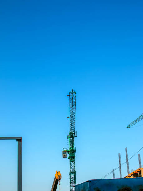 Construction crane against the blue sky. The real estate industry. A crane uses lifting equipment at a construction site. stock photo