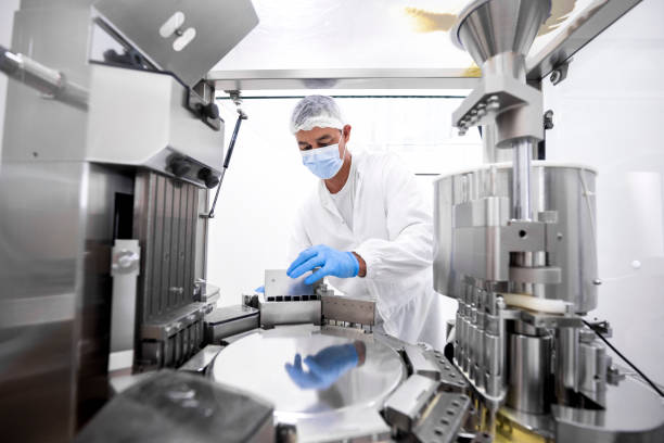 istock Pharmaceutical technician in a protective clothing equipment seen in a laboratory during a manufacturing process 1421401884