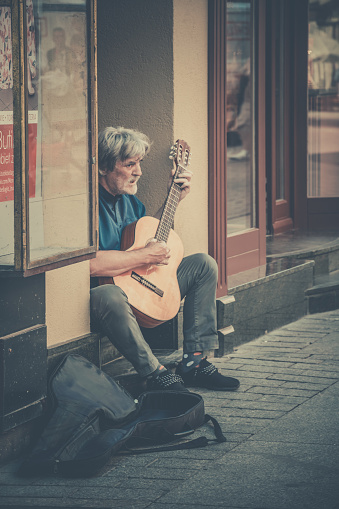 Torun, Poland - August 2020 : Street busker playing guitar in Torun Old Town