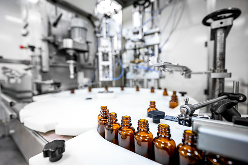 Close up on small brown bottles seen in a laboratory after production and all the proper checks during manufacturing in a pharmaceutical factory.