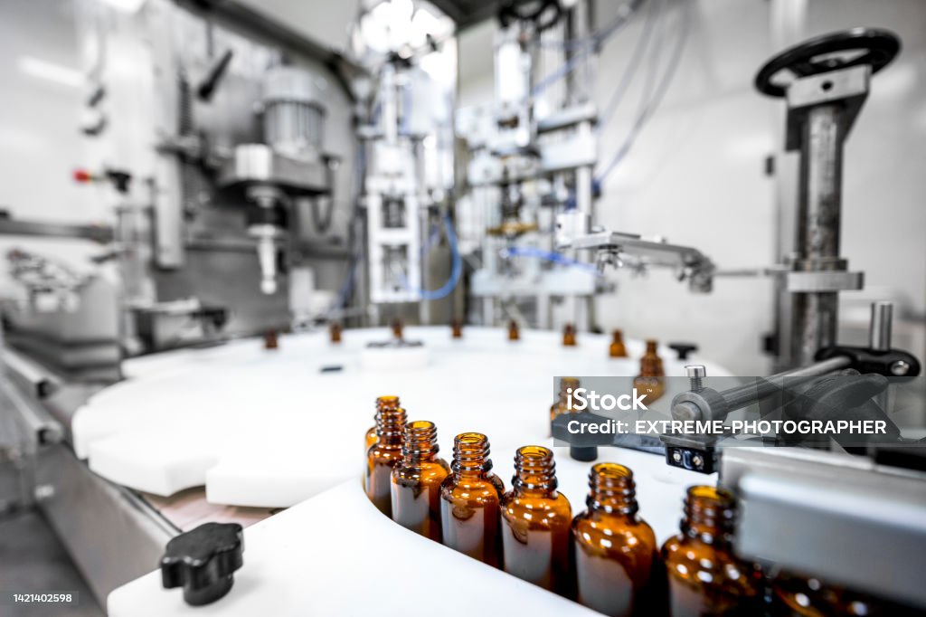 Focus on brown bottles perfectly arranged in a pharmaceutical laboratory Close up on small brown bottles seen in a laboratory after production and all the proper checks during manufacturing in a pharmaceutical factory. Manufacturing Stock Photo