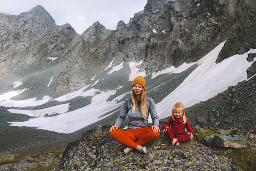 Family yoga meditation in mountains mother with child practicing outdoor together healthy lifestyle vacations outdoor parent and kid harmony with nature