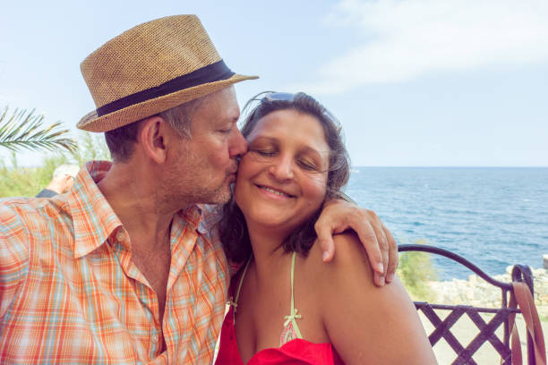 istock A man takes a selfie hugging a beautiful woman. 1421404634