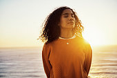 istock Beach, sunset and calm woman enjoying the fresh ocean air while relaxing on a spring vacation. Healthy, zen and peaceful girl on an adventure in nature with a wellness, free and travel lifestyle. 1421404824