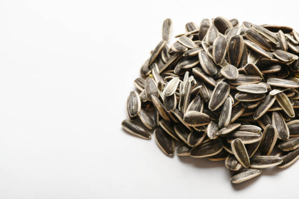 Sunflower seeds on the white background Heap of sunflower seeds on the white background with copy space Sunflower Seeds stock pictures, royalty-free photos & images