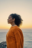 istock Relax, zen and freedom mindset of a woman at the ocean water, beach and sea in nature at sunset. Calm and positive energy of a young Moroccan female enjoying the sound of content waves at evening 1421405340