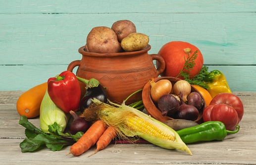 Assortment of organic vegetables and rustic pottery