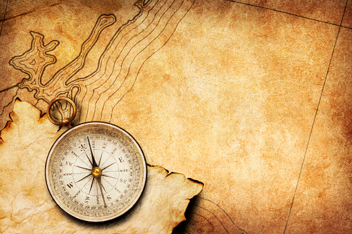 A compass rests on top of a generic old map that provides ample room for copy and text.