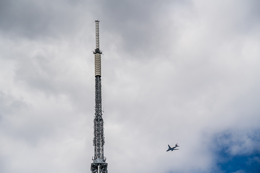 Wide shot of the iconic Eiffel Tower in Paris, France, with tourists and vehicles on a partly cloudy day.