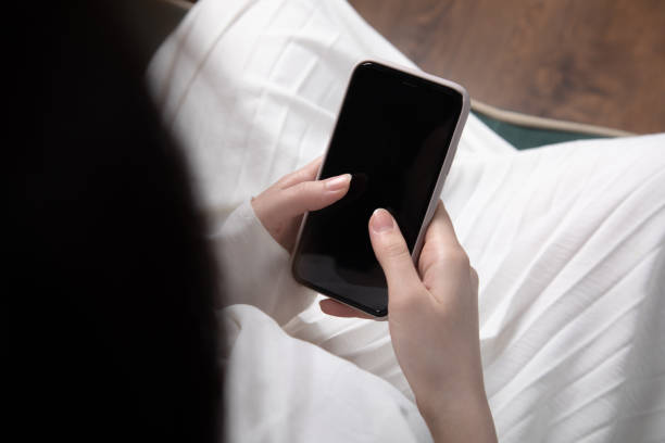 istock Woman hand holding mobile phone and sitting on sofa 1421413724