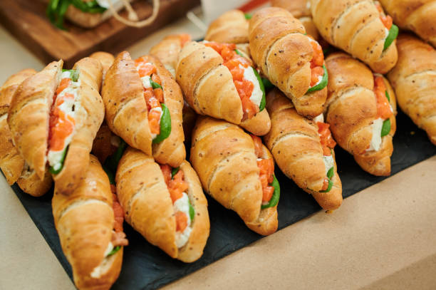 istock Croissant soft cheese sandwiches with salmon and fresh basil on the table 1421414154