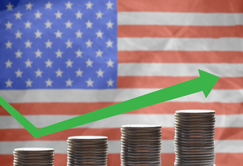 Coins on the background of the US flag Graph of income growth in America. copyspace.