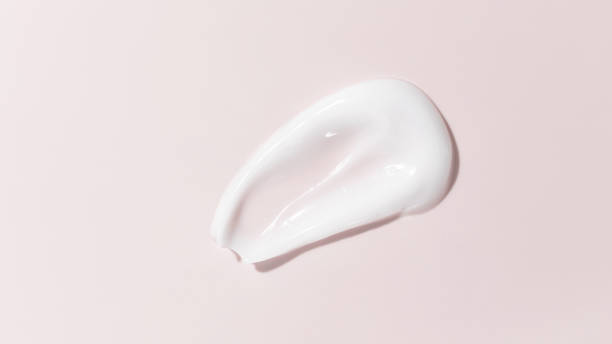 white beauty cream smear smudge on pink background. cosmetic skincare product texture. face cream, body lotion swipe swatch - facial cleanser imagens e fotografias de stock