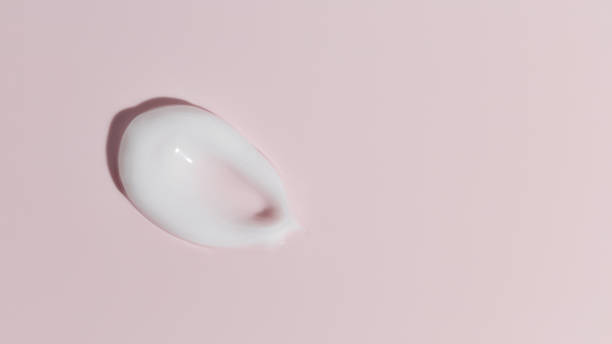 istock White cosmetic cream texture on pink background 1421415847