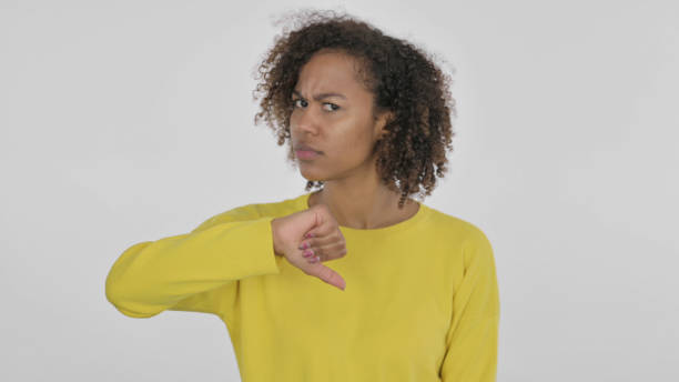 istock Thumbs Down Gesture by Young African Woman on White Background 1421417217