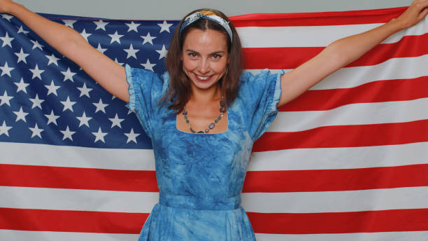 アメリカの国旗を振り回し、包み込み、人権と自由を祝う素敵な若い女性 - freedoms ストックフォトと画像