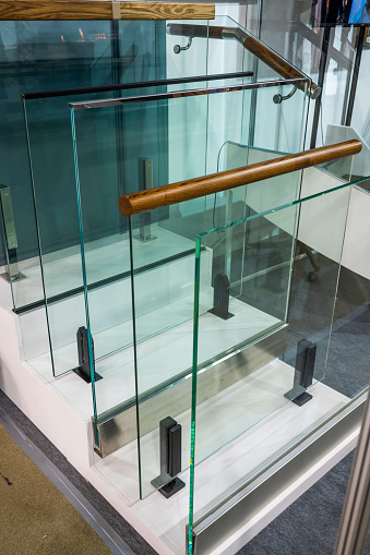 Partitions and railings made of safety glass with fasteners and railings, showcase in the construction department of the store