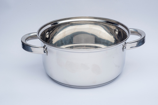 Studio shot of stainless steel Stew Pot with handles, without lid, isolated on white background, side view.