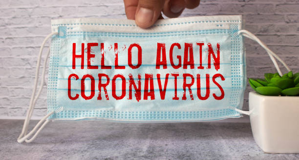 istock hello again coronavirus text on blue medical mask 1421426243