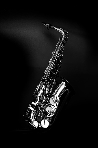 Jazz shot of a tenor saxophone, warmly lit, studio shot on white